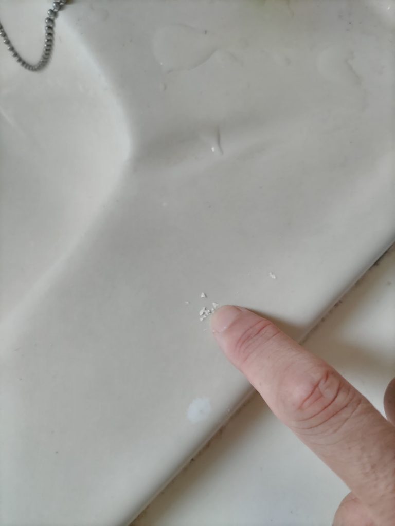 洗面台を爪でカリカリしてペンキを剥がしている写真